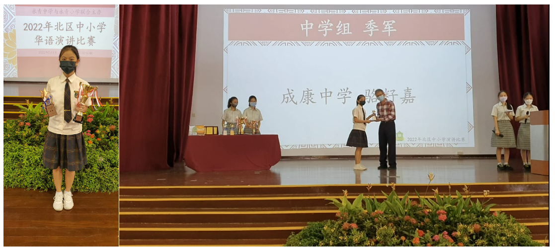 Student in uniform holds trophy beside stage where a girl receives award from adult at a 2022 Chinese speech competition.